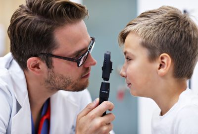 Picture of child optometry male optometrist optician doctor examines eyesight of little boy